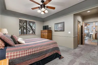 a bedroom with a bed and a ceiling fan at Lazy Bear Lodge Rustic Luxe Villa with spa & gameroom in Shaver Lake