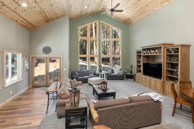 a living room with couches and a flat screen tv at Lazy Bear Lodge Rustic Luxe Villa with spa & gameroom in Shaver Lake