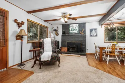 a living room with a fireplace and a table at Smoke Tree-Newly Updated Family Retreat in Shaver Lake
