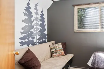 a living room with a couch and trees on the wall at Smoke Tree-Newly Updated Family Retreat in Shaver Lake