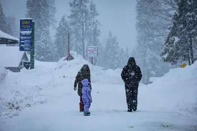 two adults and a child walking down a snow covered road at Smoke Tree-Newly Updated Family Retreat in Shaver Lake