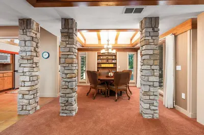 a dining room with stone columns and a table at Single level Family cabin-Fenced in yard for pets & kids in Shaver Lake