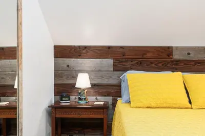 a bedroom with a bed with a wooden headboard at Cedar Horn- Serene Family Shaver Retreat in Shaver Lake