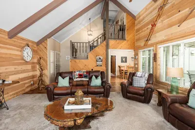 a living room with leather furniture and a table at Cedar Horn- Serene Family Shaver Retreat in Shaver Lake
