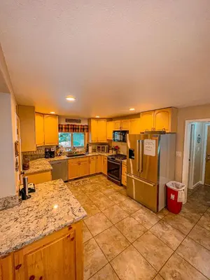 a kitchen with yellow cabinets and stainless steel appliances at Bear Bottoms Family Cabin-Huge GAME ROOM in Shaver Lake