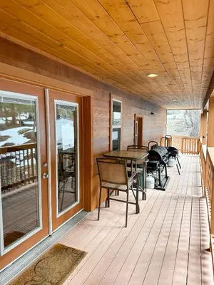 a wooden deck with a table and chairs on it at Bear Bottoms Family Cabin-Huge GAME ROOM in Shaver Lake