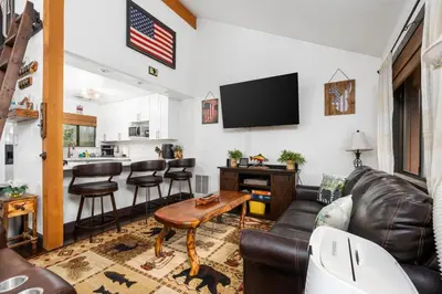 a living room with a couch and a table at Kamp Kokanee-Updated Condo Near Spa Sauna in Shaver Lake