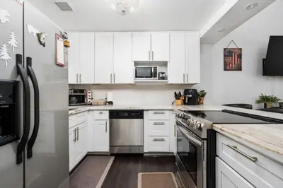 a kitchen with white cabinets and stainless steel appliances at Kamp Kokanee-Updated Condo Near Spa Sauna in Shaver Lake