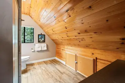 a bathroom with a wooden ceiling with a toilet at Black Diamond-Family Pet Friendly & Near China Peak in Big Creek
