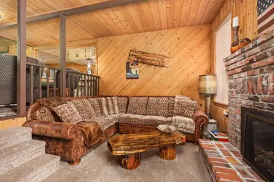 a living room with a couch and a fireplace at Wyldwood-Family Friendly-LOFT & BAR in Shaver Lake