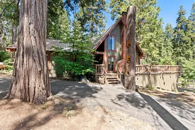 a log cabin with a tree in front of it at Wyldwood-Family Friendly-LOFT & BAR in Shaver Lake