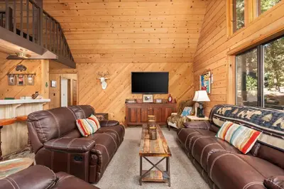 a living room with leather couches and a flat screen tv at Wyldwood-Family Friendly-LOFT & BAR in Shaver Lake