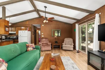 a living room with a green couch and a kitchen at Happy Bear- Family & Pet Friendly in Shaver Lake