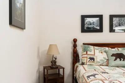 a bedroom with a bed and some pictures on the wall at Happy Bear- Family & Pet Friendly in Shaver Lake