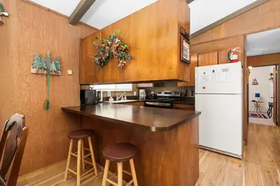 a kitchen with wooden cabinets and a white refrigerator at Happy Bear- Family & Pet Friendly in Shaver Lake