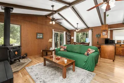 a living room with a green couch and a stove at Happy Bear- Family & Pet Friendly in Shaver Lake