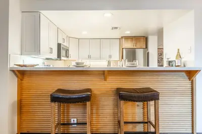 a kitchen with a wooden bar with two stools at Snowcreek V 870 in Mammoth Lakes