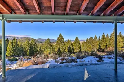 a view from the inside of a porch with snow and trees at A Quiet Escape in Truckee