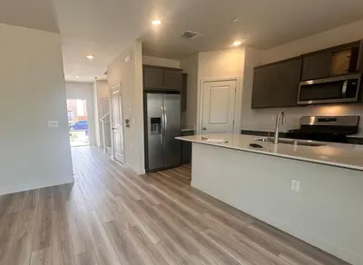 an empty kitchen with a counter top and a refrigerator at A modern retreat and Gateway to Yosemite in Merced