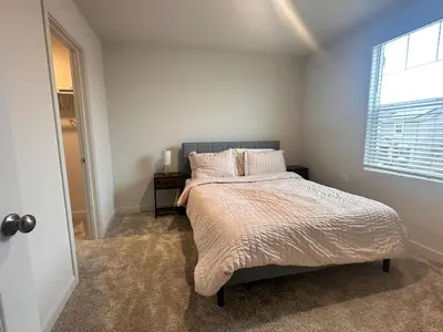 a bedroom with a large bed with a window at A modern retreat and Gateway to Yosemite in Merced