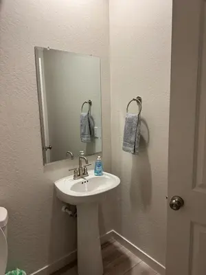 a bathroom with a white sink and a mirror at A modern retreat and Gateway to Yosemite in Merced