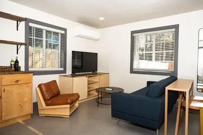 a living room with a blue couch and a tv at The Coachman Hotel in South Lake Tahoe