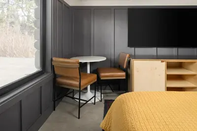 a room with a table and two chairs and a tv at The Coachman Hotel in South Lake Tahoe