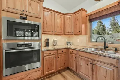 a kitchen with wooden cabinets and stainless steel appliances at Evergreen Getaway Pet Friendly in SLT w Hot Tub in South Lake Tahoe