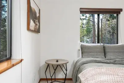 a bedroom with a bed and a table next to a window at Kokanee Hideaway-Family Friendly 5BR Epic Game Room in Shaver Lake