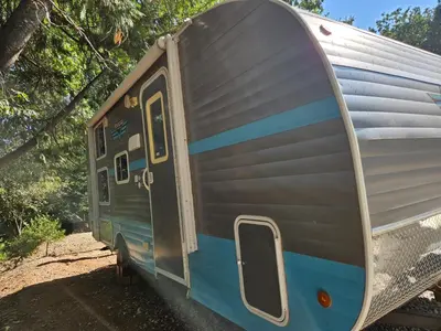 a blue and silver trailer parked in the dirt at Gold Rush Historical Resort in Sonora