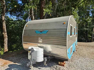 a metal trailer parked on the gravel near trees at Gold Rush Historical Resort in Sonora