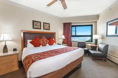 a hotel room with a bed and a chair and a window at Enjoy the Ridge Tahoe Two-Bedroom Lock-Off for a family of 6 in Stateline