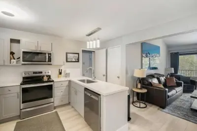 a kitchen and living room with a stove and a couch at Guest Favorite Spacious Remodeled 2 Bdrm 2 Ba Mountain Views in Mammoth Lakes