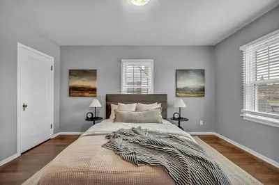 a bedroom with a large bed and two windows at New-Near Midtown-HotTub-Firepit-Arlington Manor in Reno