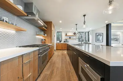 a kitchen with wooden cabinets and stainless steel appliances at Aerial Grace Lakeside – 4BR Luxury w/ Private Beach, Pier, Sauna in Tahoma