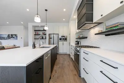 a kitchen with white countertops and stainless steel appliances at Starfall Run at Palisades by Tahoe Getaways - Luxury 3BR w Ski Shuttle, A/C & Bonus Room! in Alpine Meadows