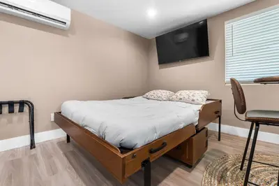a bedroom with a bed with a tv on the wall at Boho Chic Dt Visalia W Modern Art Flair in Visalia