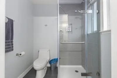 a bathroom with a toilet and a glass shower at Amazing Views Hot Tub-Games-Fire pit 6BR Sleeps 20 in Oakhurst