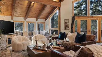 a living room with leather furniture and windows at Near Ski Resorts Downtown Truckee Donner Lake Basque Lodge by AvantStay in Truckee