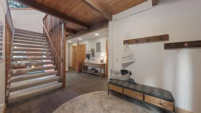 a living room with a staircase and a chair at Near Ski Resorts Downtown Truckee Donner Lake Basque Lodge by AvantStay in Truckee