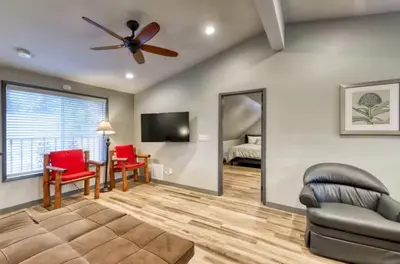 a living room with a ceiling fan and a mirror at Villager in the Heart of Shaver Family Friendly in Shaver Lake