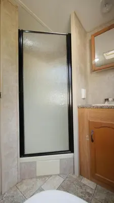 a bathroom with a sliding glass shower door at Cedar Springs Retreats in North Fork