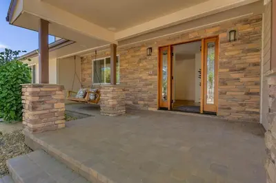 a home with a stone wall and a patio at Marbella Lane - Eccentric 4BR Modern Ranch Home in Reno