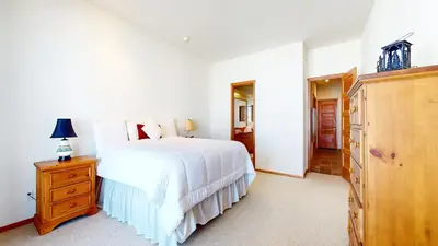 a bedroom with a white bed and a wooden dresser at Snowcreek V #819 condo in Mammoth Lakes