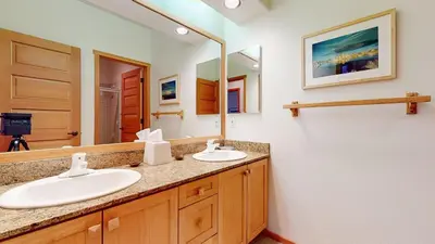 a bathroom with two sinks and a large mirror at Snowcreek V #819 condo in Mammoth Lakes