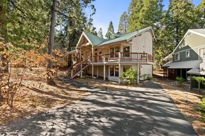 a house in the woods with a driveway at Silverpine Chalet with Gym Family Friendly in Shaver Lake