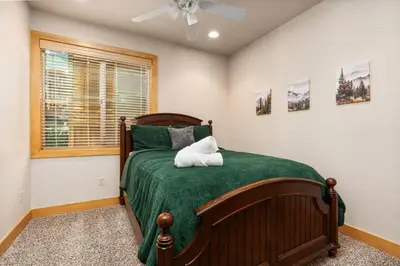 a bedroom with a bed with a green bedspread at Sierra Pines- Family friendly Game Room & Fire Pit in Shaver Lake