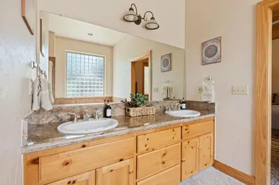 a bathroom with two sinks and a large mirror at Sierra Pines- Family friendly Game Room & Fire Pit in Shaver Lake