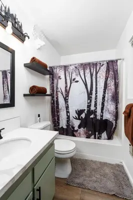 a bathroom with a toilet and a shower curtain at Wilderness Hideaway-Across from the pool & spa in Shaver Lake