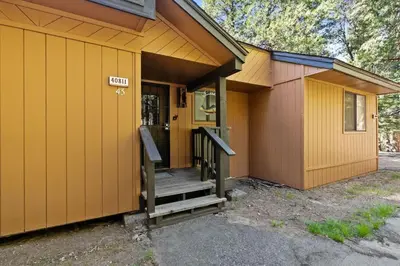 a small house with a staircase leading to the door at Wilderness Hideaway-Across from the pool & spa in Shaver Lake